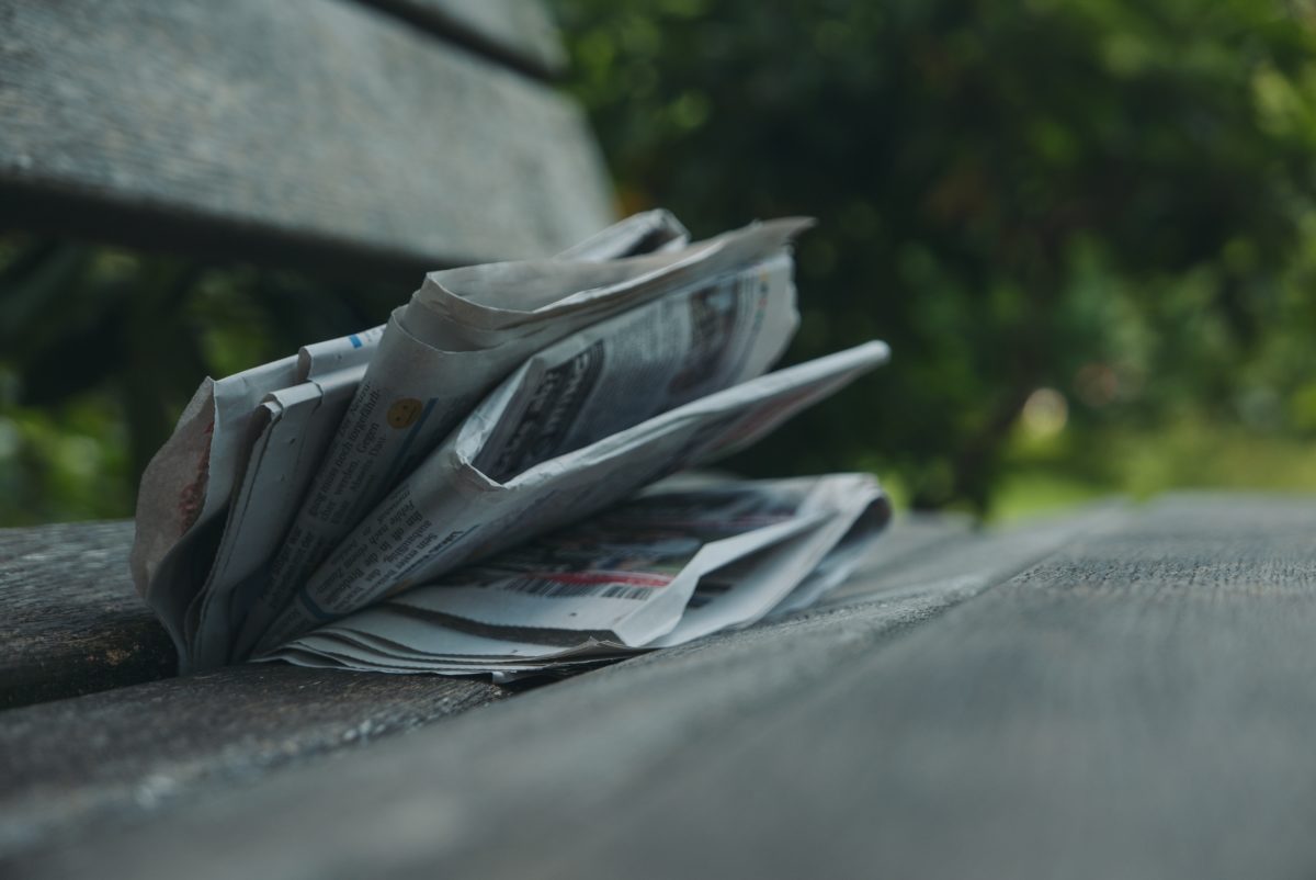 newspaper sitting on a bench