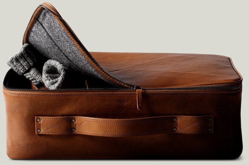 Brown suitcase with the left corner unzipped and lifted.