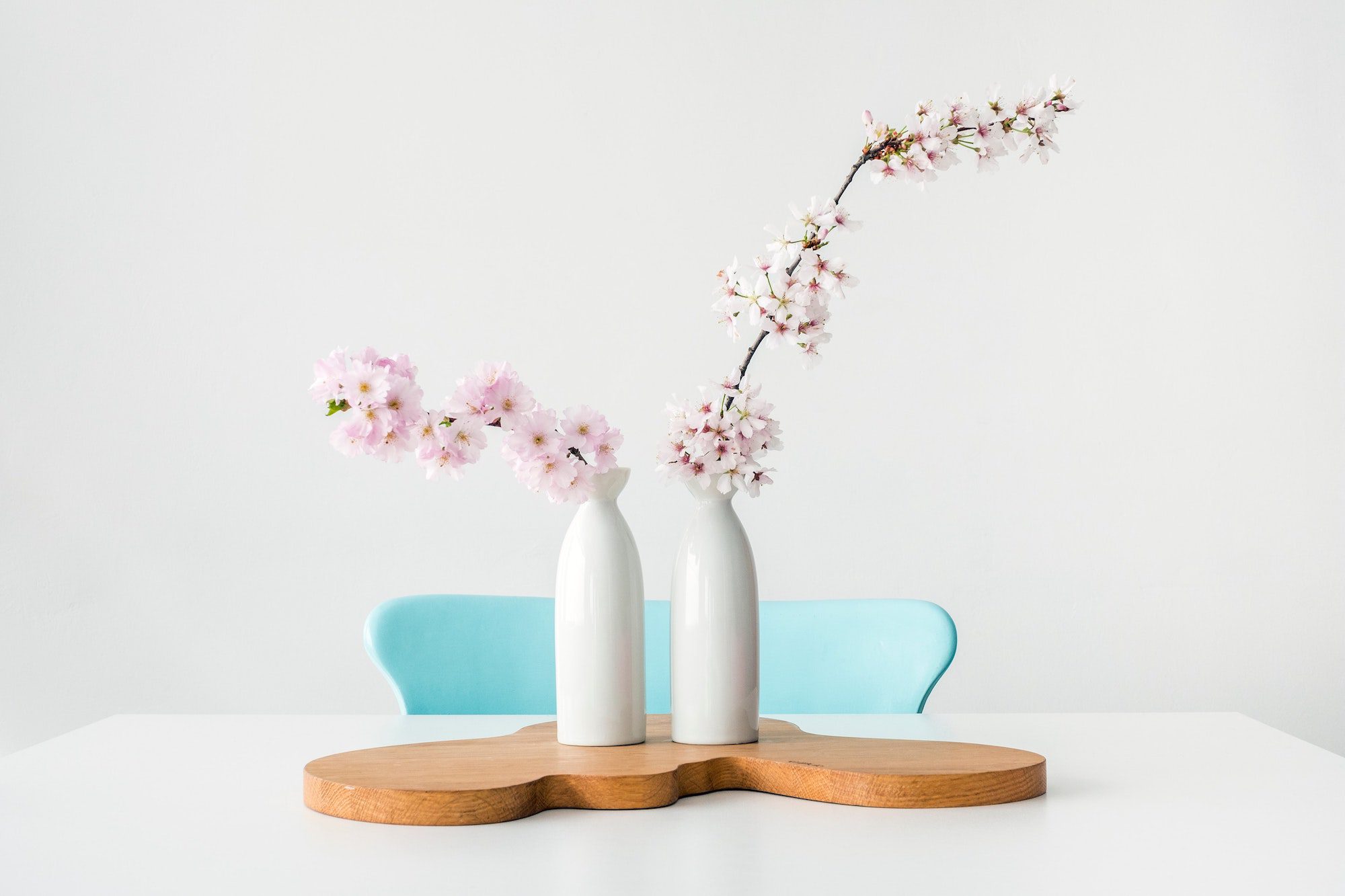 Clean dining table with vased full of cherry blossom branches