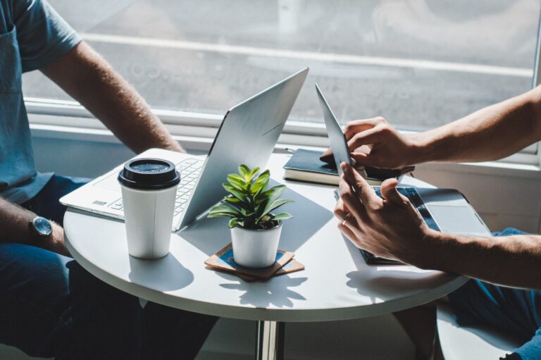 Photo of two people having a meeting with their laptops