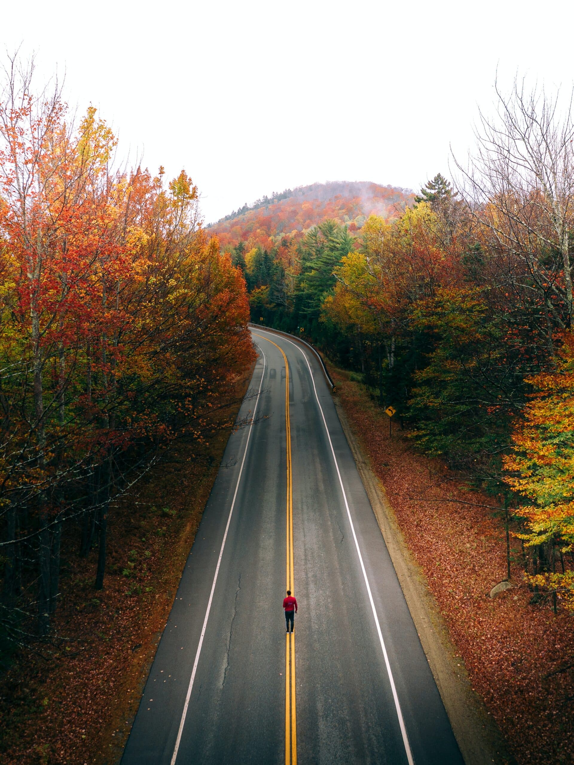 Photo of a person standing in the middle of an empty road