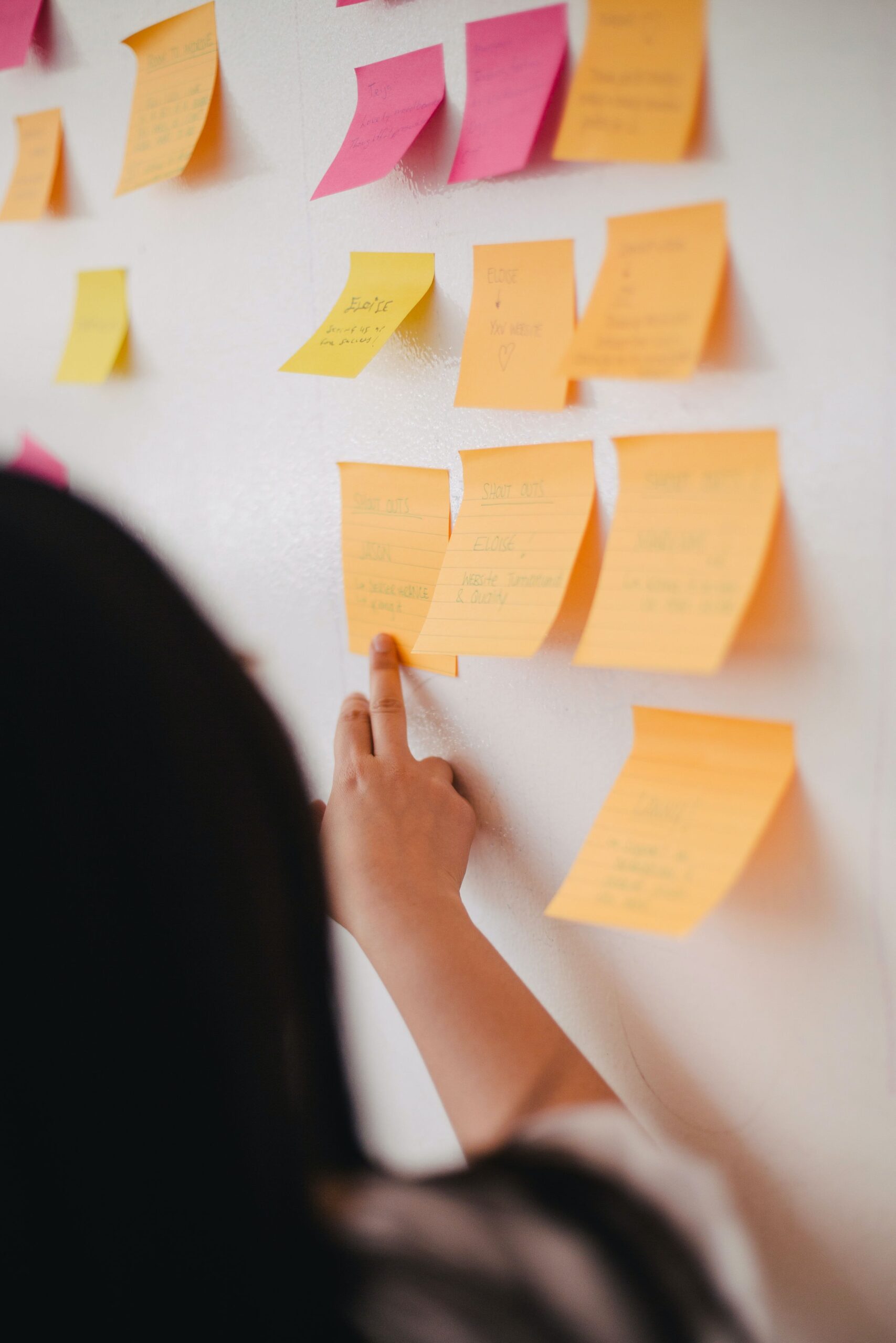 Photo of a person reading from sticky notes on a wall