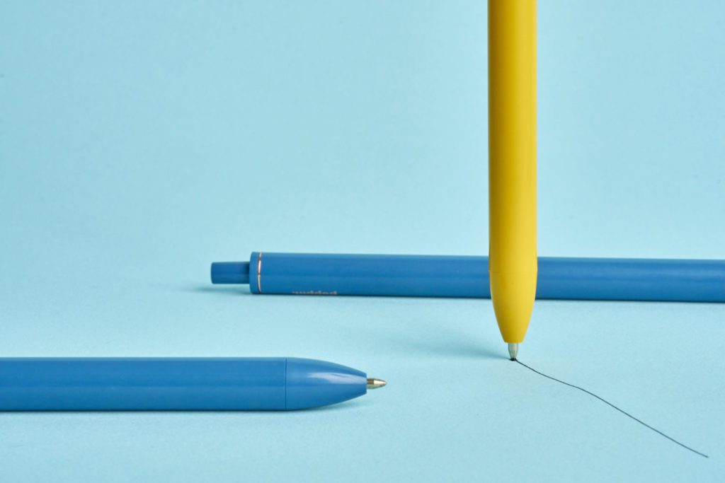 Blue and yellow pens on blue background