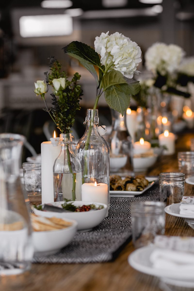 selective focus photography of white flowers beside lighted candle on table