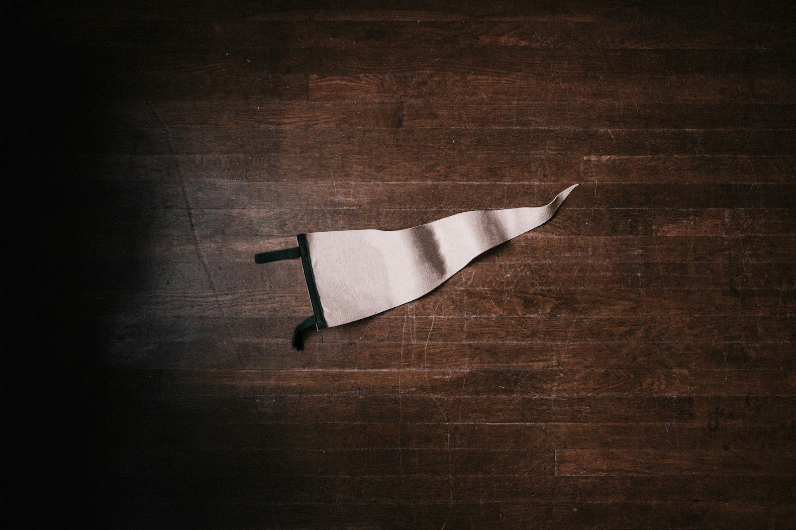 a crumpled white flag on a dark wooden floor